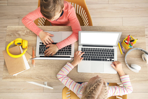 Evde çalışan sevimli küçük çocuklar. Çevrimiçi eğitim kavramı - Fotoğraf, Görsel