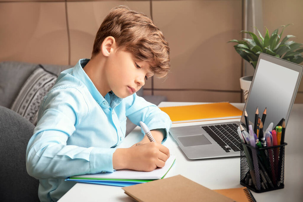Aranyos kisfiú, otthon tanul. Az online oktatás fogalma - Fotó, kép