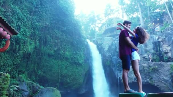 Hermosa chica que pasa un buen rato con su novio cerca de la cascada, video concepto de viaje  - Metraje, vídeo