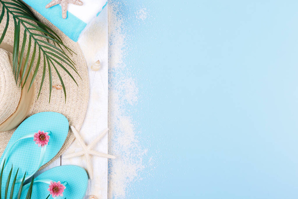 Аксессуары для пляжа на голубом фоне, солнцезащитные очки, солнцезащитный крем, шлепанцы, полотенце и шляпа, летние каникулы, копировальное пространство
 - Фото, изображение