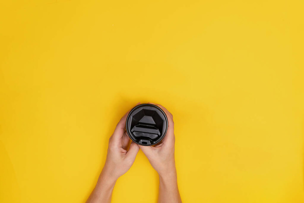 Woman caucasian with take away coffee with black lid on yellow background. - Foto, Bild