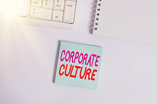 Handschriftliches Textschreiben Corporate Culture. Konzept bedeutet allgegenwärtige Werte und Einstellungen, die ein Unternehmen charakterisieren Leeres Notizpapier auf weißem Hintergrund durch die PC-Tastatur mit Kopierraum. - Foto, Bild