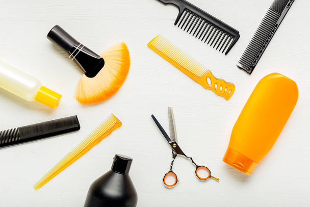 Hairdresser tools, hair salon equipment for professional hairdressing in beauty salon, haircut service. Top view flat lay on white background.Hairbrush, comb, scissors, shampo. Orange black set. - Photo, Image