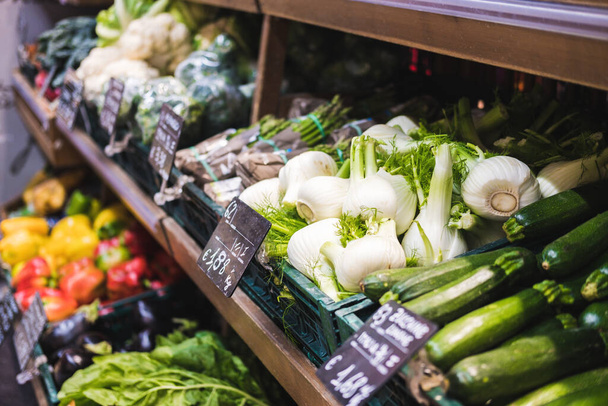 Fresh vegetables on the shelves of a supermarket with price tags in Italian. Selective Focus. - 写真・画像