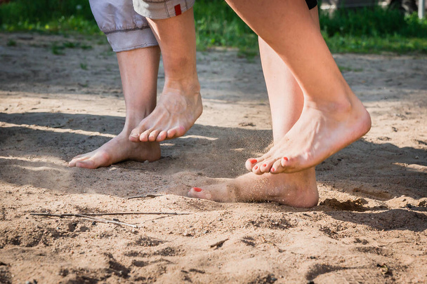 Un hombre y una mujer con los pies descalzos pisan la arena descalzos
 - Foto, imagen