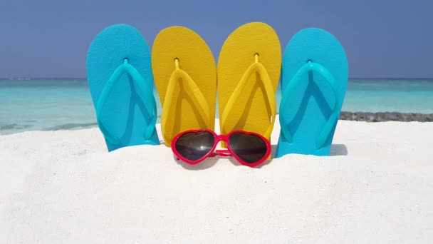 Žluté a modré žabky s červenými slunečními brýlemi na pláži. Výlet na Barbados, Karibik. - Záběry, video