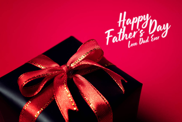 Fête des pères heureux concept de fond avec vue de dessus de boîte cadeau noire avec rubans isolés sur fond de thème sombre
. - Photo, image