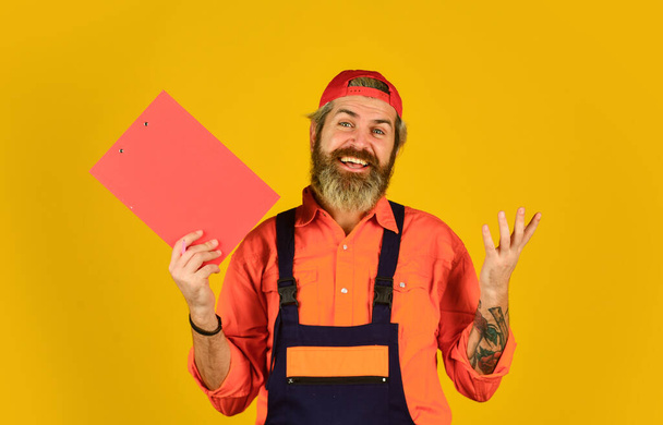 Bearded storekeeper. Supplier of goods. Delivery man in cap holding clipboard looking information. Check list. Control concept. Courier with document. Waybill or delivery note. Delivery service - Foto, afbeelding