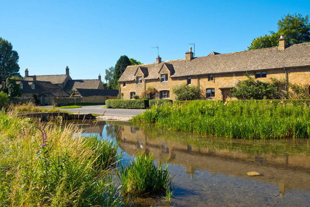 Summer sunshine on the well known visitor attraction of picturesque Lower Slaughter village in the Cotswolds AONB (Area Of Outstanding Natural Beauty) in Gloucestershire, UK - Photo, Image
