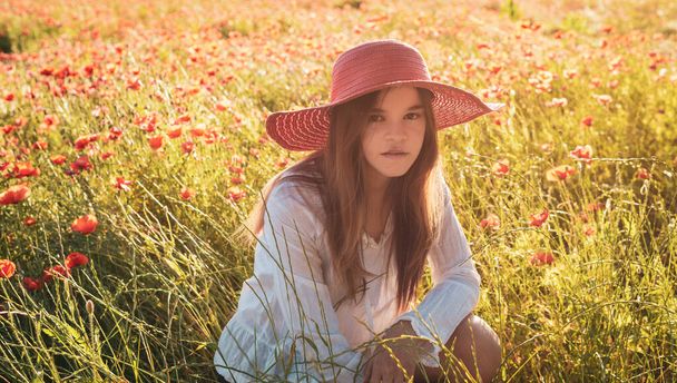 Young woman sitting  in poppy feild., wearing red stra w hat ,relaxing ,provence France. - Fotoğraf, Görsel