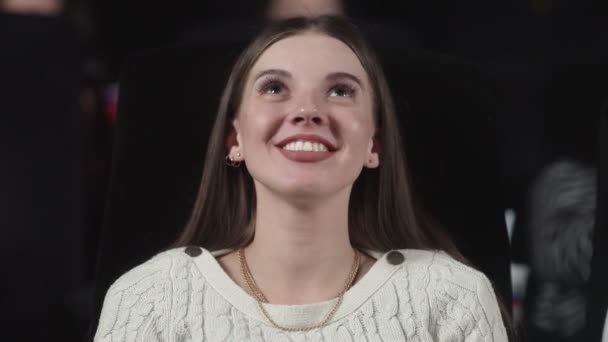 Nuori nainen elokuvissa alkaa hymyillä ja nauraa - Materiaali, video