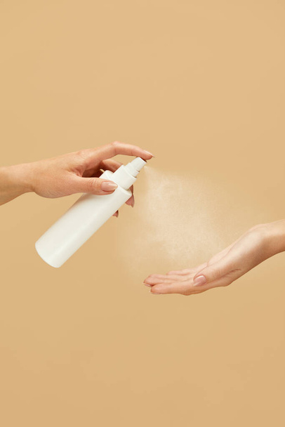 Antiseptic. Female Hands Using Spray Sanitizer On Beige Background. Daily Hygiene Routine With Antibacterial Products For Virus Prevention And Staying Healthy.  - 写真・画像
