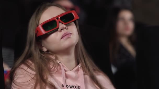 Jeune femme avec des lunettes 3D regarde un film au cinéma - Séquence, vidéo