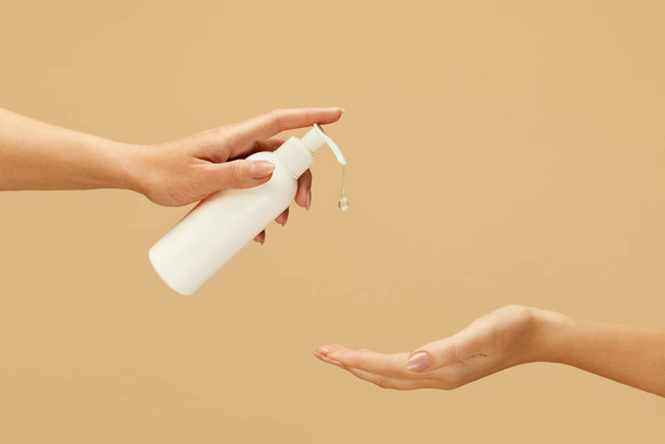 Antiseptic. Female Hands Using Gel Sanitizer On Beige Background. Daily Hygiene Routine With Antibacterial Products For Virus Prevention And Staying Healthy.  - Фото, изображение