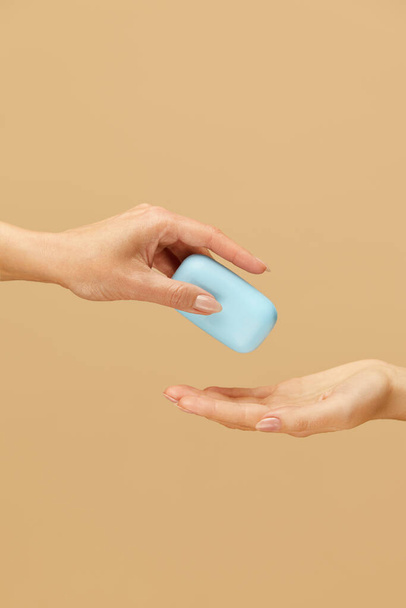 Hands Hygiene. Soap Bar In Caucasian Female Palm On Beige Background. Daily Personal Washing Routine As Virus And Bacterial Infection Prevention.  - Φωτογραφία, εικόνα