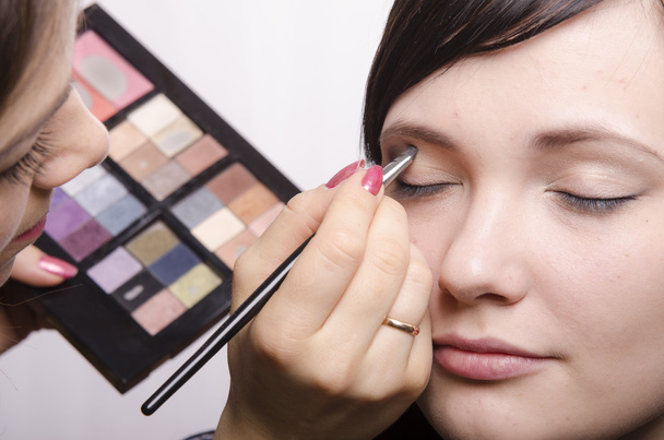 Makeup artist in the process of makeup colors upper eyelids model - Photo, Image