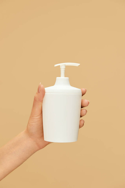 Hygiene. Liquid Soap Bottle In Caucasian Female Hand On Beige Background. Daily Personal Hygiene Routine And Skin Care For Virus Prevention. Wash Your Hands For Staying Healthy.  - Foto, afbeelding
