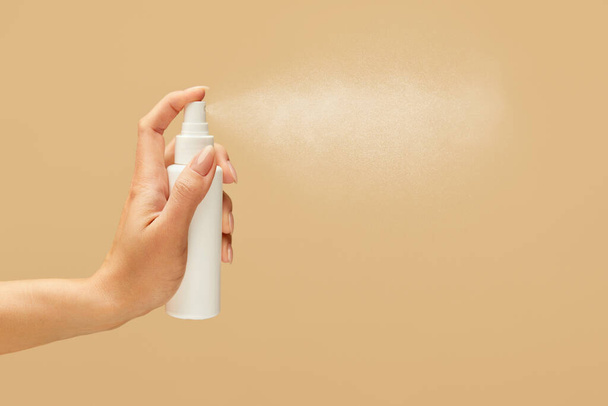 Hygiene. Hand Spraying Antiseptic On Beige Background. Using Sanitizer For Virus Prevention And Staying Healthy.  - Фото, изображение
