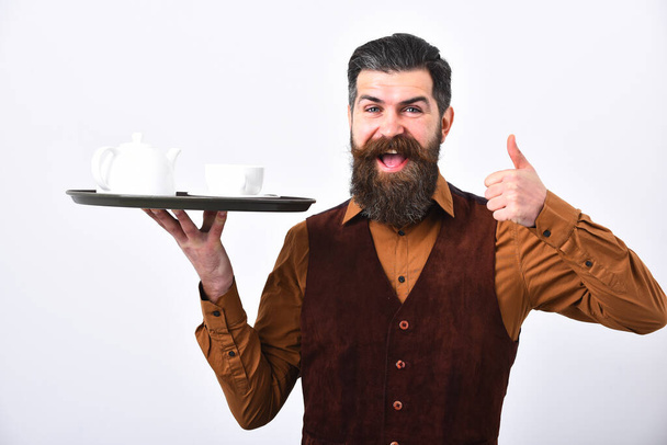 Barman with happy face serves tea showing thumbs up. - Foto, afbeelding