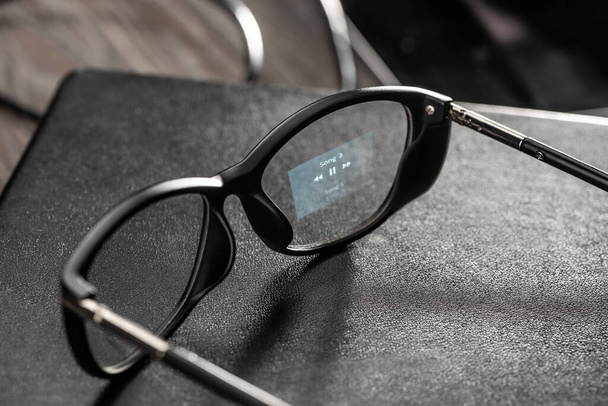 Smart glasses with music player app projected onto the lens - Zdjęcie, obraz