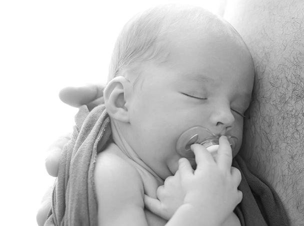Makro zdjęcie noworodka, małe zbliżenie ucha. Dziecko śpiące z smoczkiem w ustach na klatce piersiowej ojca. Szczęśliwego Dnia Ojca! - Zdjęcie, obraz