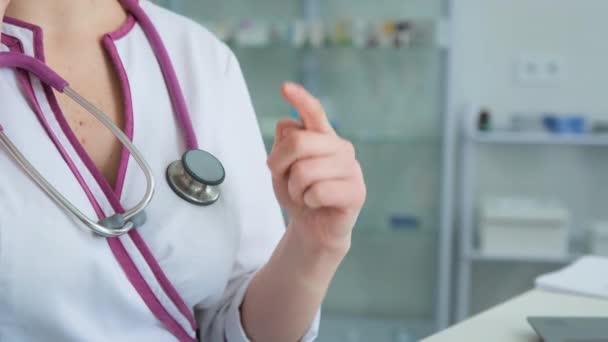 Clouse fel orvosi személyzet Kórház női orvos gesztusok a kezét, és számít az ujját a klinikán egy fehér kabátban ül - Felvétel, videó