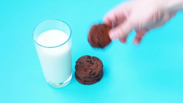 Dip american chocolate cookie in milk. Closeup view. Tasty sweet food - Кадри, відео