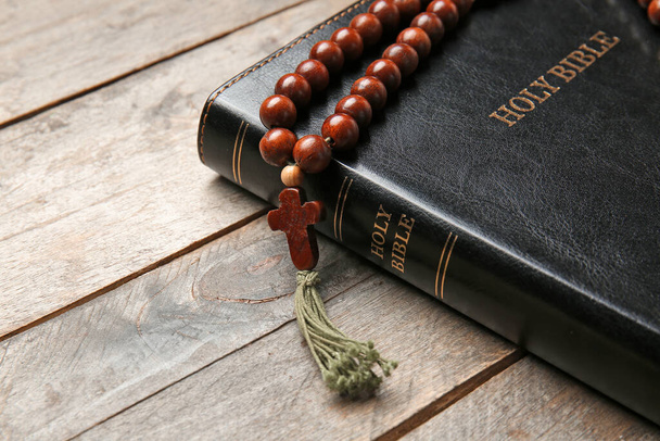 Holy Bible and rosary beads on wooden background, closeup - Fotografie, Obrázek
