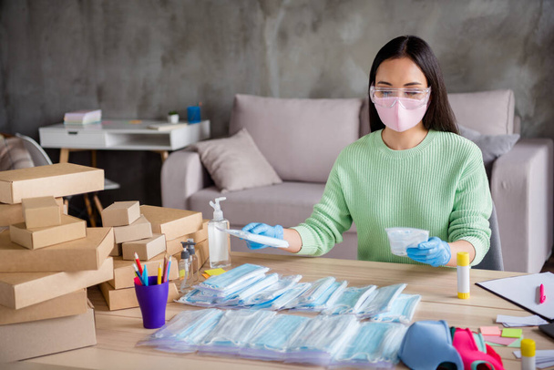 Photo of chinese lady hands latex gloves business organize order face medical masks handmade package sorting carton boxes online delivery shop commerce manager home office indoors - Foto, immagini