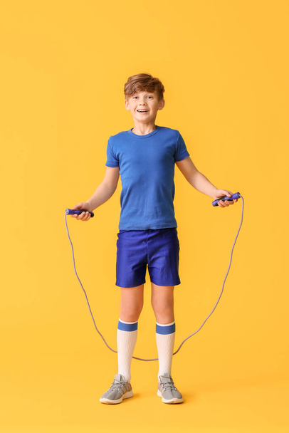 Piccolo ragazzo sportivo con corda di salto su sfondo di colore
 - Foto, immagini