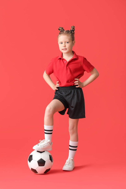 Маленькая девочка с футбольным мячом на цветном фоне
 - Фото, изображение