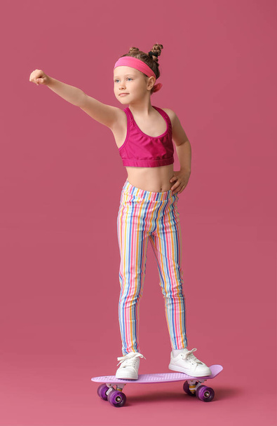 Sporty little girl with skateboard on color background - Photo, image