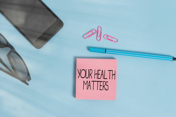 Schreiben Sie eine Notiz, in der Ihre Gesundheit eine Rolle spielt. Business-Foto zeigt gute Gesundheit ist am wichtigsten unter anderem Brille farbige Haftnotiz Smartphone Handy Pen Pastell Hintergrund. - Foto, Bild