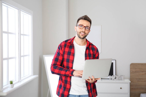 Junger Mann mit Laptop arbeitet zu Hause - Foto, Bild