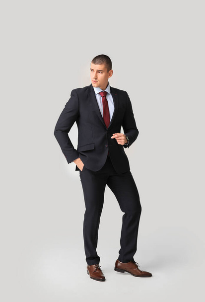 Handsome young man in elegant suit on light background - Photo, Image