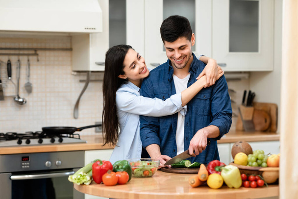 Giovane coppia preparare insalata insieme a casa
 - Foto, immagini