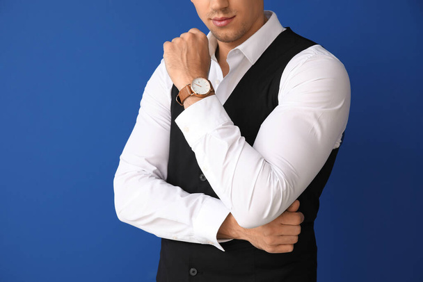 Hezký mladý muž v elegantním obleku na barevném pozadí - Fotografie, Obrázek