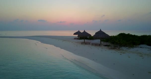 Coucher de soleil sur la plage avec parasols en paille. Détente estivale aux Maldives, Asie du Sud. - Séquence, vidéo