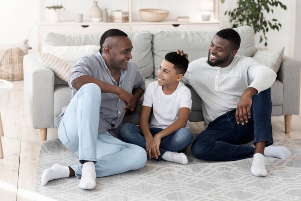 正のアフリカ系アメリカ人多世代男性家庭で一緒に休む - 写真・画像