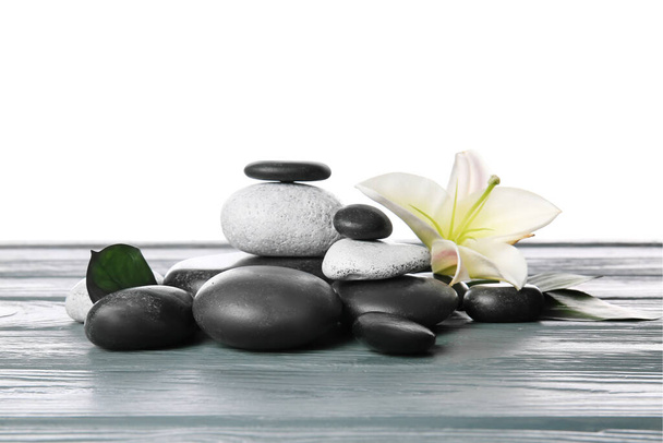 Kamienie zen i kwiat na stole na białym tle - Zdjęcie, obraz