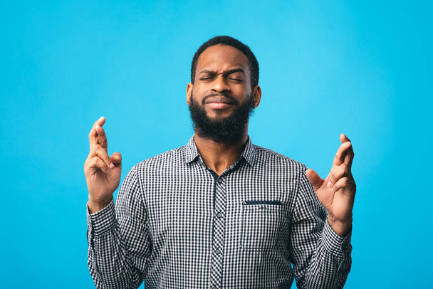Um americano africano esperançoso a cruzar os dedos
 - Foto, Imagem