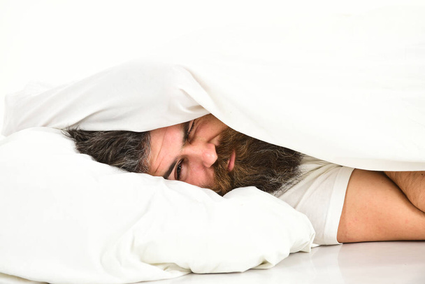 Guy with beard hides face under blanket. - Foto, afbeelding
