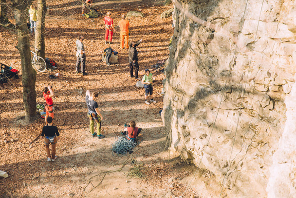 Lviv, Ucrania - 9 de abril de 2018: gente cálida de primavera escalando en la roca en el bosque. espacio de copia
 - Foto, imagen