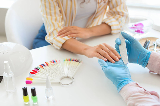 Manicure master werken met vrouwelijke klant in schoonheidssalon - Foto, afbeelding
