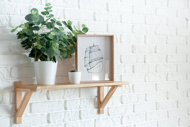 Shelf with decor and houseplant on brick wall - Photo, image