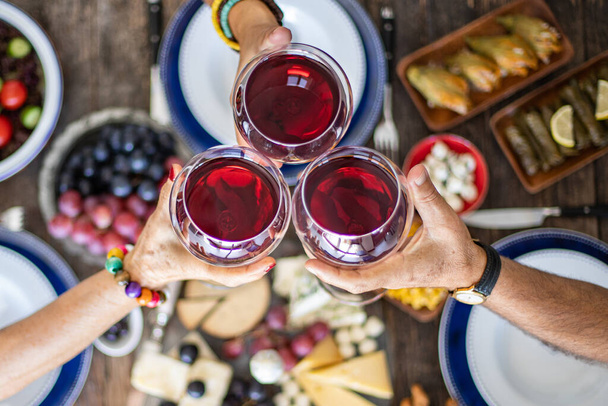 Cena familiar para una celebración con vino tinto y salud. Vista superior de una cena familiar (comida) con unión - Foto, imagen