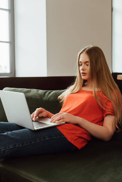 freelancer atraente usando laptop na sala de estar
  - Foto, Imagem