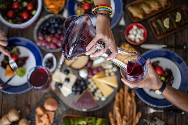 Семейный ужин для празднования с красным вином и ура. Вид сверху на семейный ужин (трапезу) с весельем - Фото, изображение