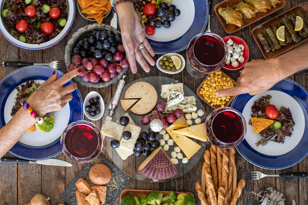 Familie diner voor een feest met rode wijn en proost. Top uitzicht op een familiediner (maaltijd) met saamhorigheid - Foto, afbeelding