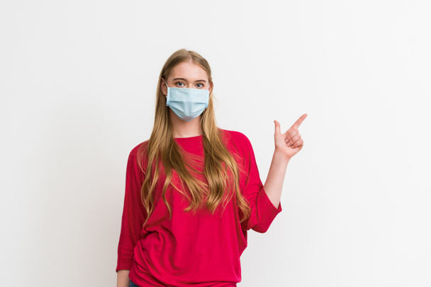young woman in medical mask pointing with finger isolated on white  - Photo, Image